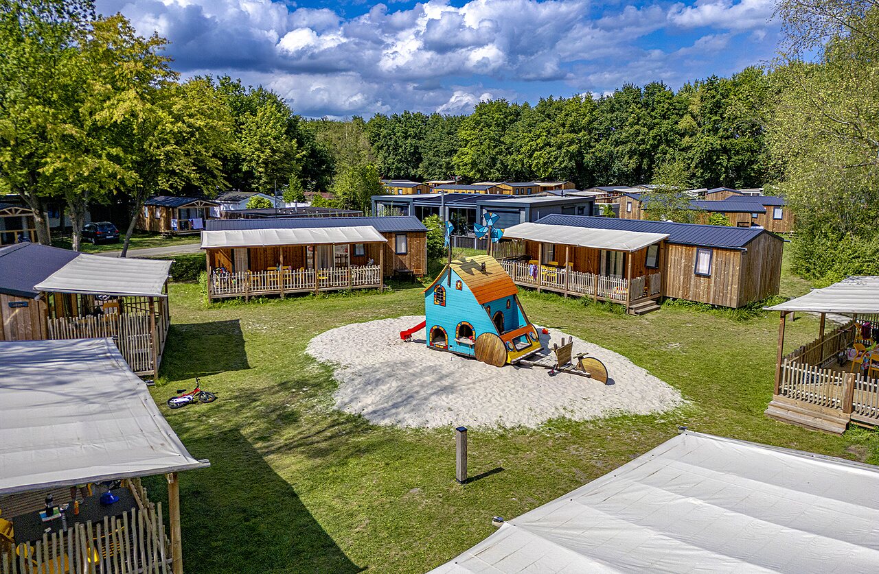 Colorful playground and wooden Mobile Homes at CAPFUN Vlinderloo campsite in Enschede.