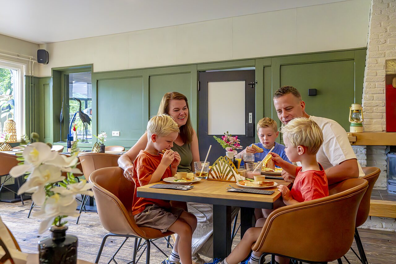 Family having lunch at the restaurant of CAPFUN Vlinderloo campsite in Enschede.