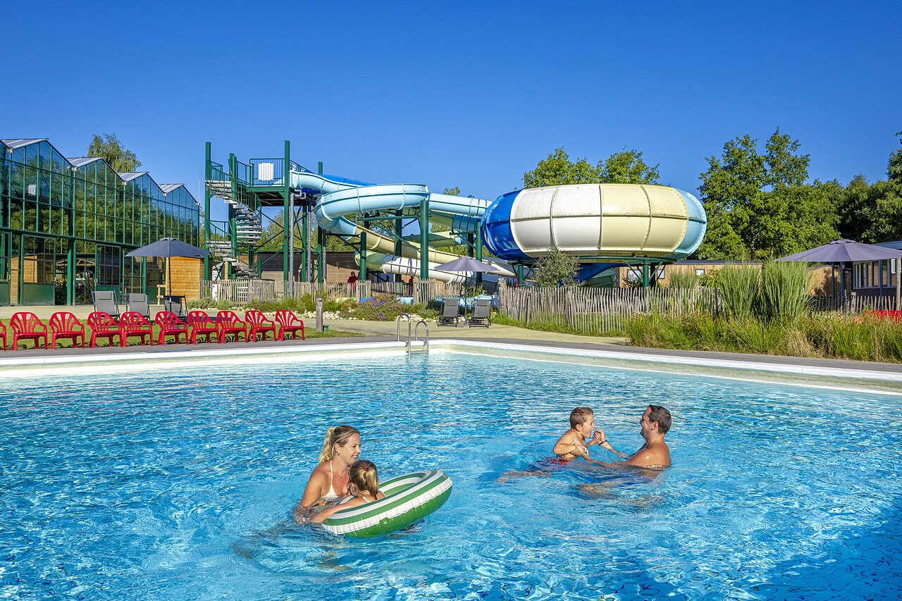 Family enjoying outdoor pool with water slides at CAPFUN Vlinderloo, Enschede.