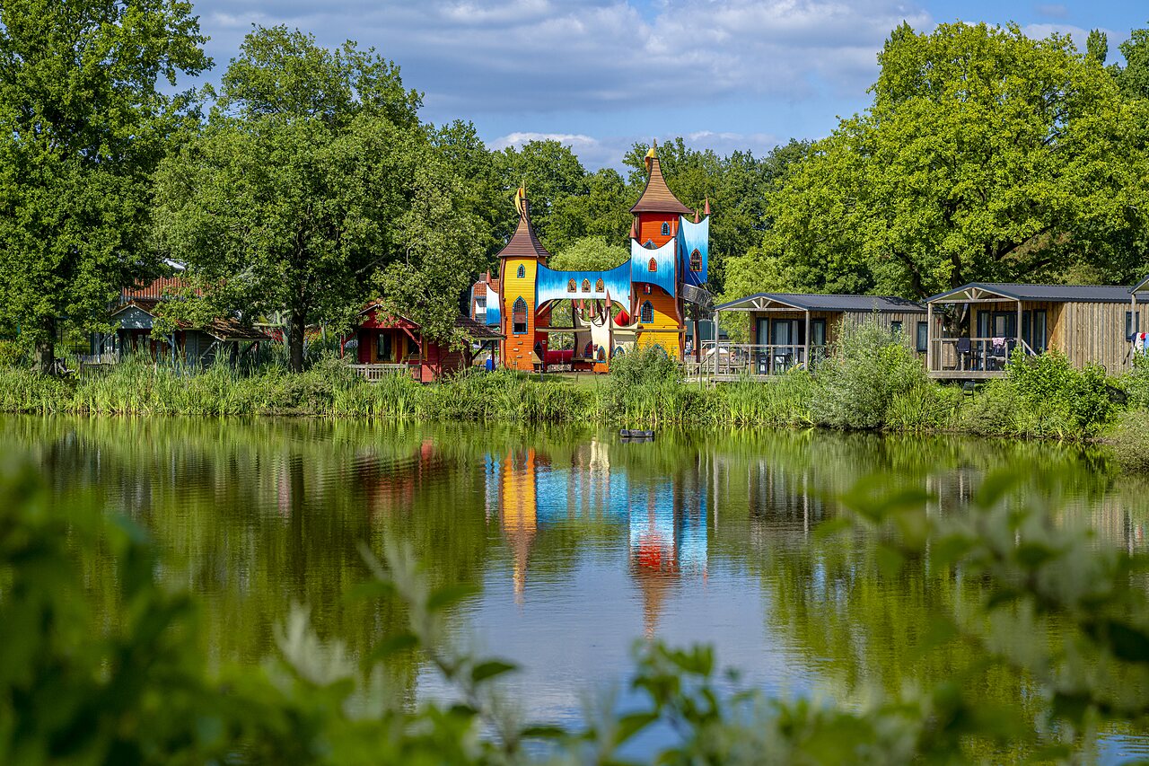Colorful castle playground, Mobile homes and lake at CAPFUN Vlinderloo campsite in Enschede.