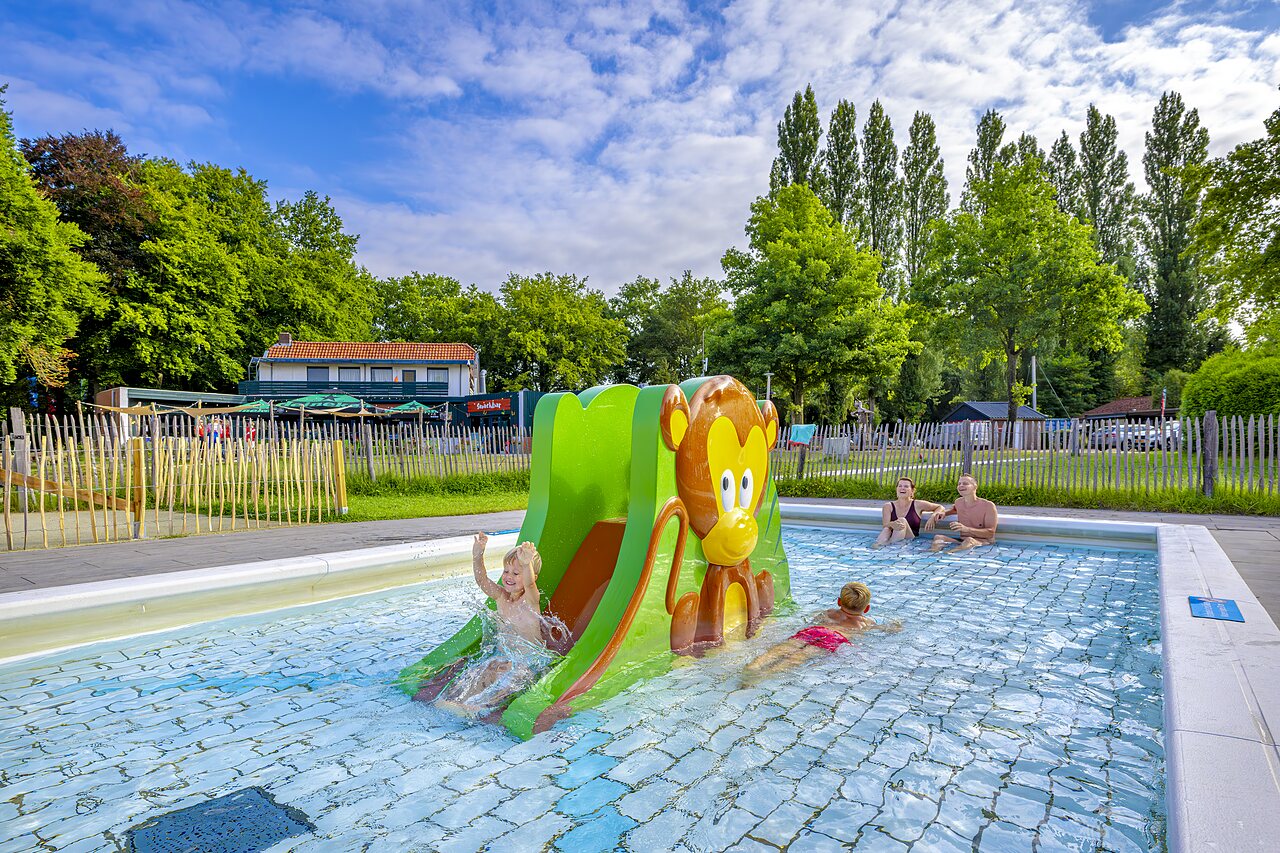 Outdoor swimming pool with children's slide at CAPFUN Vlinderloo campsite in Enschede.