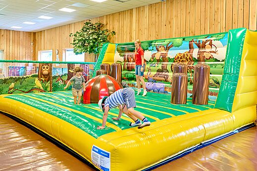 Children playing on an indoor inflatable play structure at CAPFUN De Waldsang campsite in Bakkeveen.