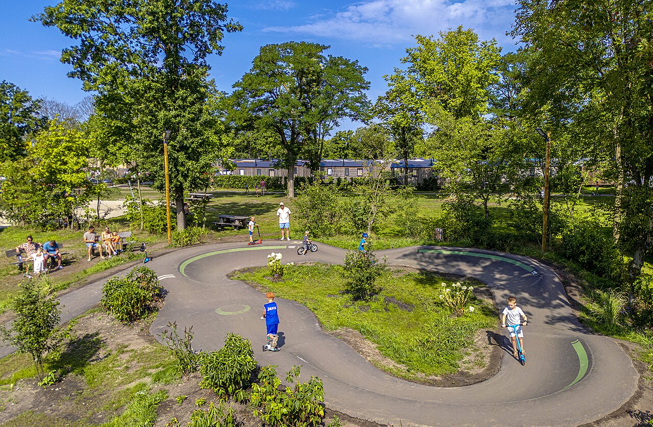 Kids on pump track with scooters and bikes at CAPFUN Wondermolen Molenschot.