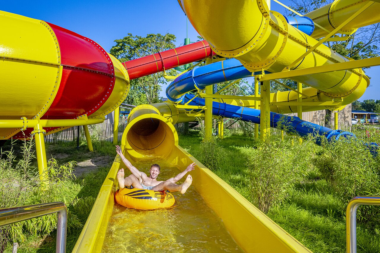 Man on tube in colorful water slide at CAPFUN Wondermolen, Molenschot.