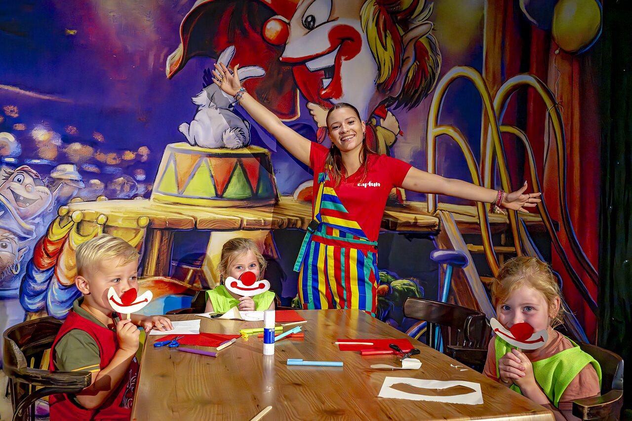 Children creating clown masks with the animator at CAPFUN de Wondermolen campsite in Molenschot.
