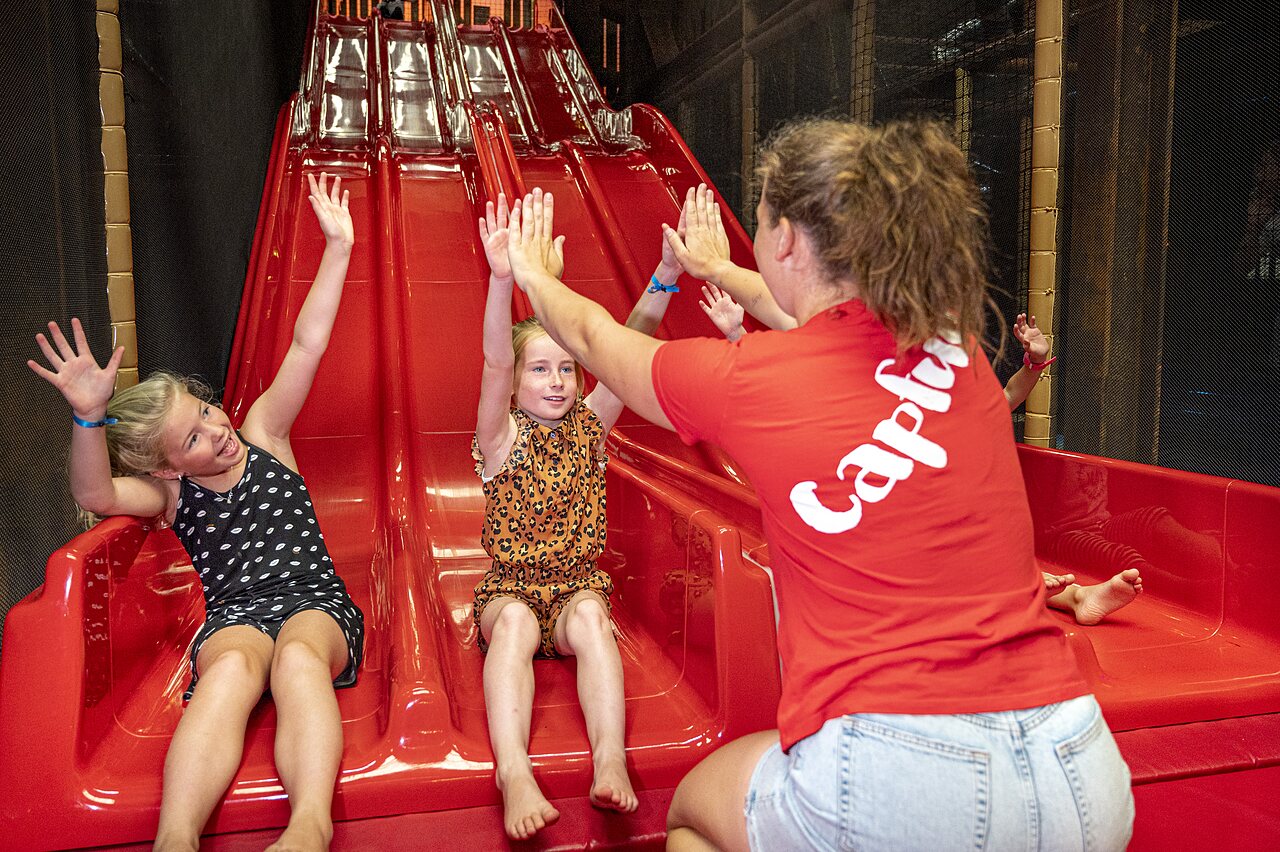 Children playing on an indoor slide with animator at CAPFUN campsite de Wondermolen in Molenschot.