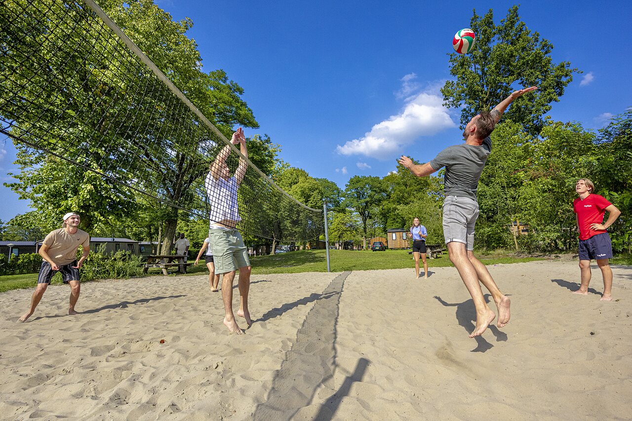Beach volleyball players on sand court at CAPFUN Wondermolen campsite in Molenschot.
