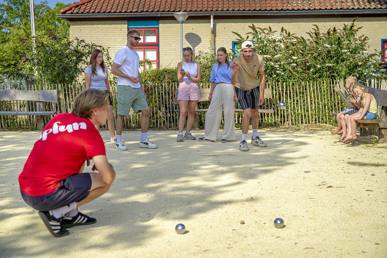 Young people playing p�tanque game at CAPFUN Wondermolen campsite in Molenschot.