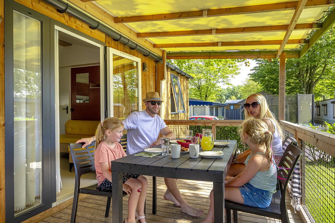 Family dining on mobile home terrace at CAPFUN Wondermolen campsite in Molenschot.