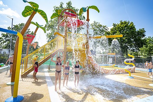 Water play area with giant tipping bucket and children at CAPFUN Wondermolen campsite in Molenschot.