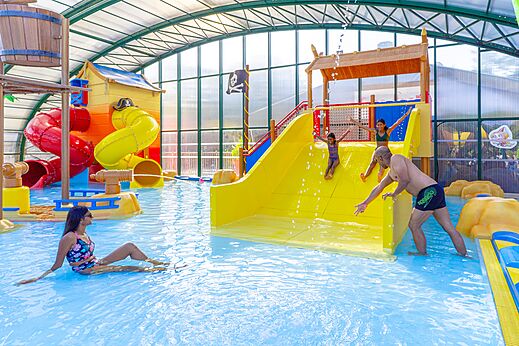 Indoor swimming pool, slides and water games at CAPFUN Zagarella campsite (85).