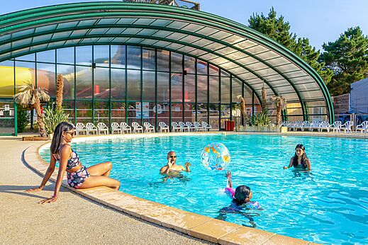 Outdoor pool, water slide and family at CAPFUN Zagarella campsite.