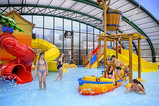 Indoor pool with slides and water games for children at CAPFUN Zagarella campsite in LONGEVILLE SUR MER (85).